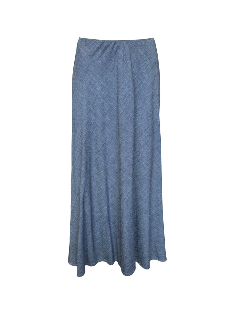 An image of the Joanie’s skirt against a white background. The skirt is a maxi slip style slip-on skirt in a dark chambray color. 